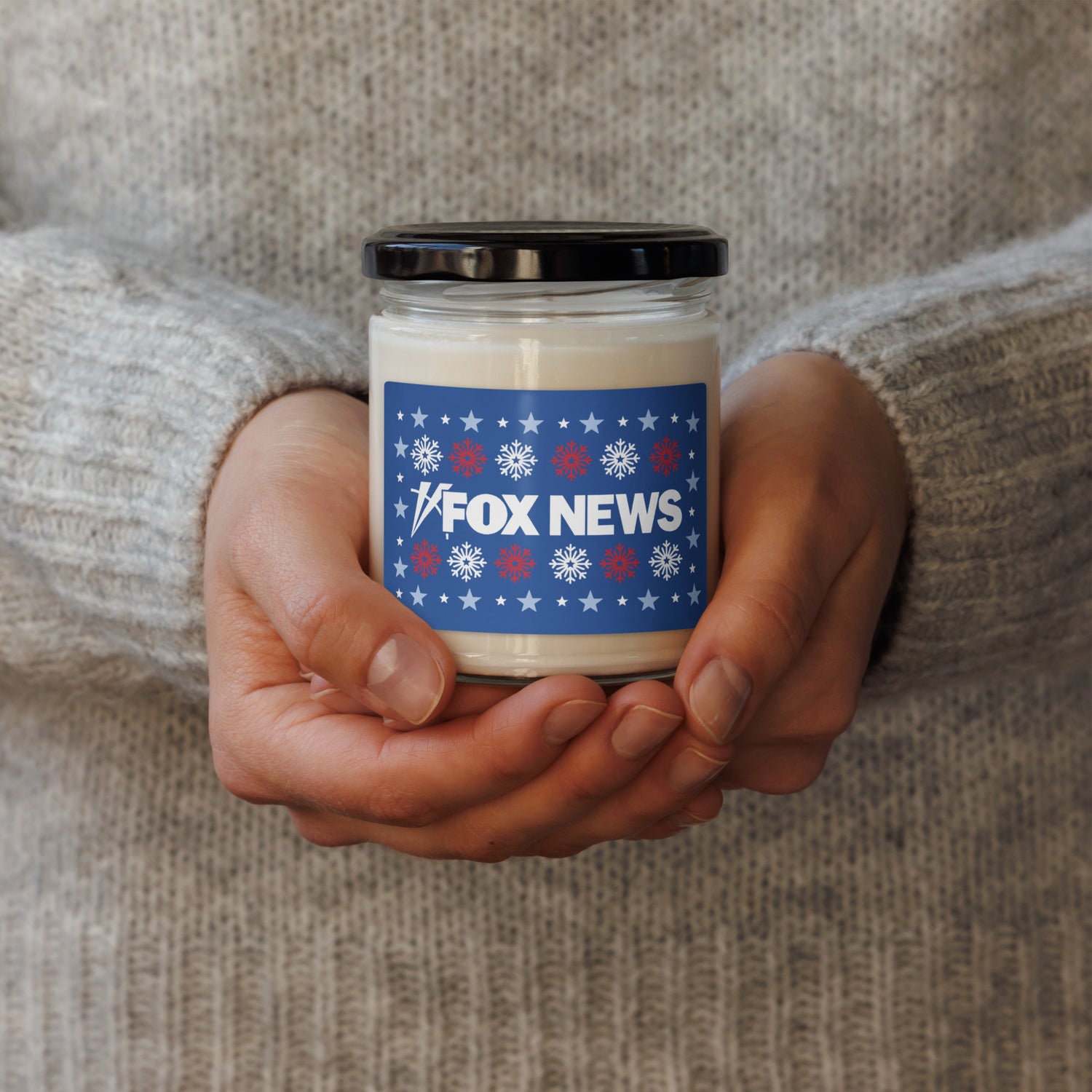 A warm holiday setting featuring a lit FOX News scented candle casting a soft, comforting glow during a winter evening.