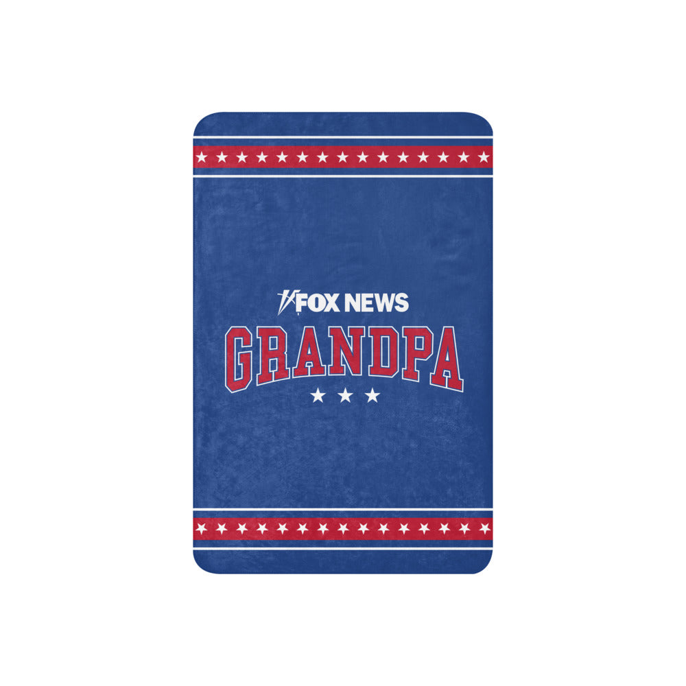 A grandfather relaxing in a suburban living room with the FOX News Sherpa Blanket covering his lap.