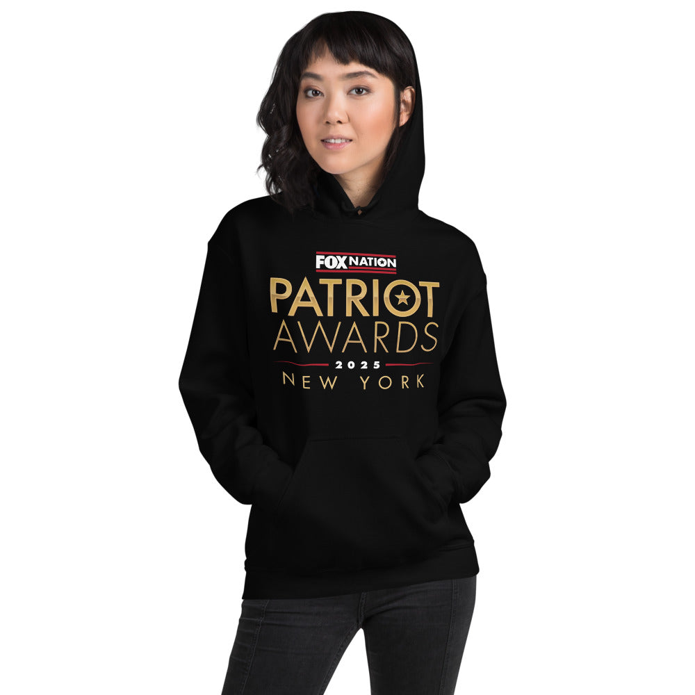 A person wearing the unisex FOX Nation Patriot Awards 2025 Hoodie in a comfortable American home setting.