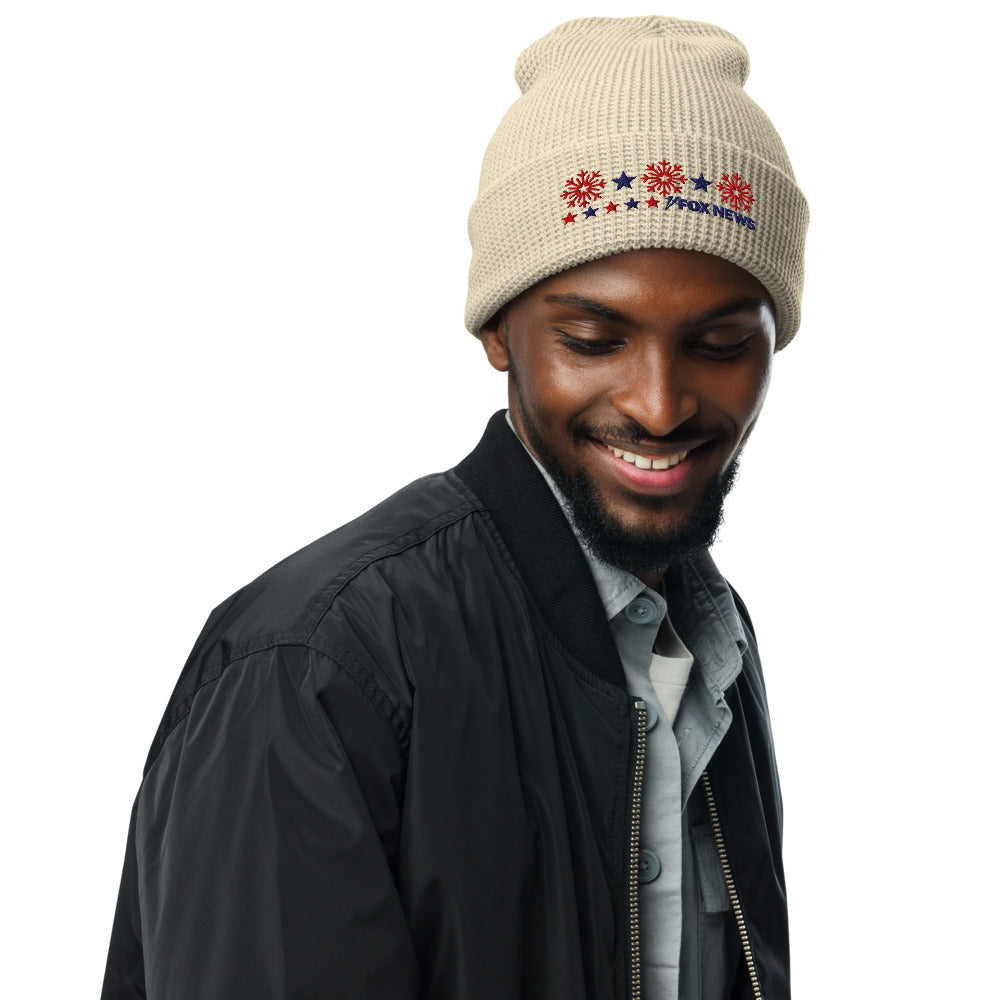 Close up of the Birch colored waffle knit beanie showing the snowflake pattern and FOX News logo.