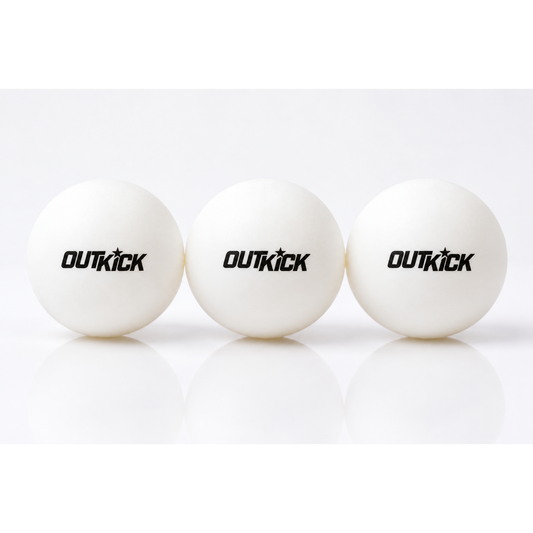 Three OutKick branded ping pong balls arranged neatly next to their custom retail packaging box in a bright, modern American game room setting