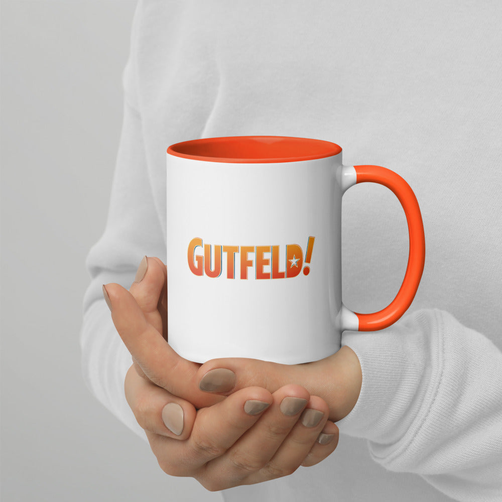 The *Gutfeld!* Two-Tone Mug displayed in a comfortable American home office setting.
