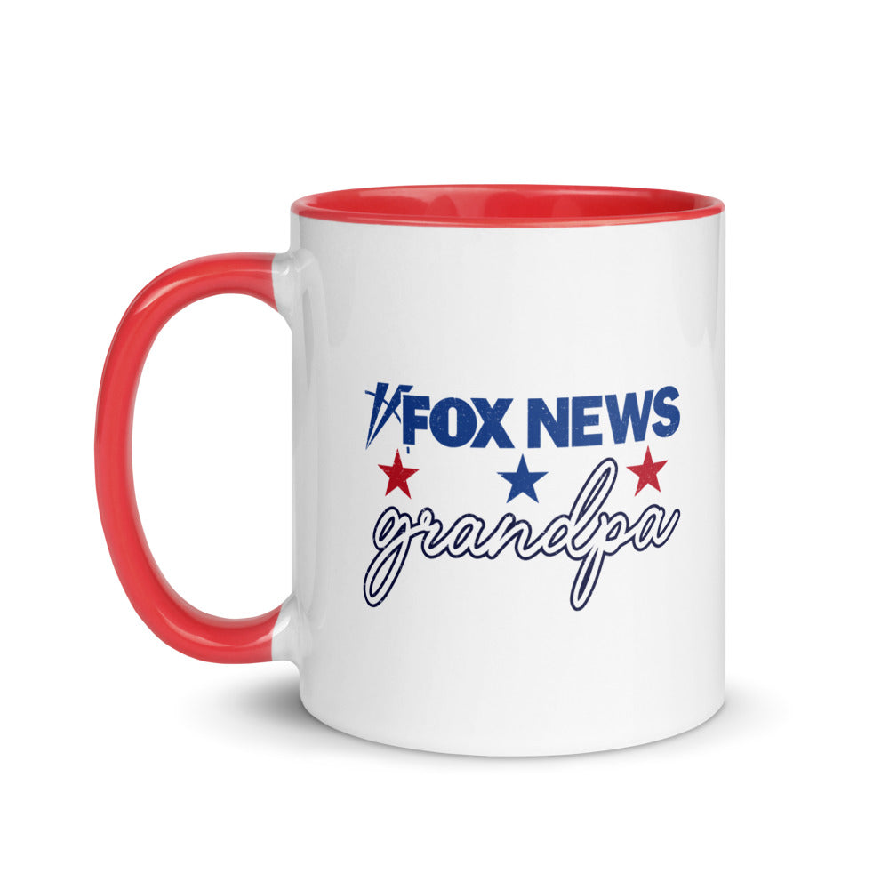 A modern American living room with a red and dark blue two-tone ceramic FOX News Grandpa mug resting on a clean wooden coffee table.