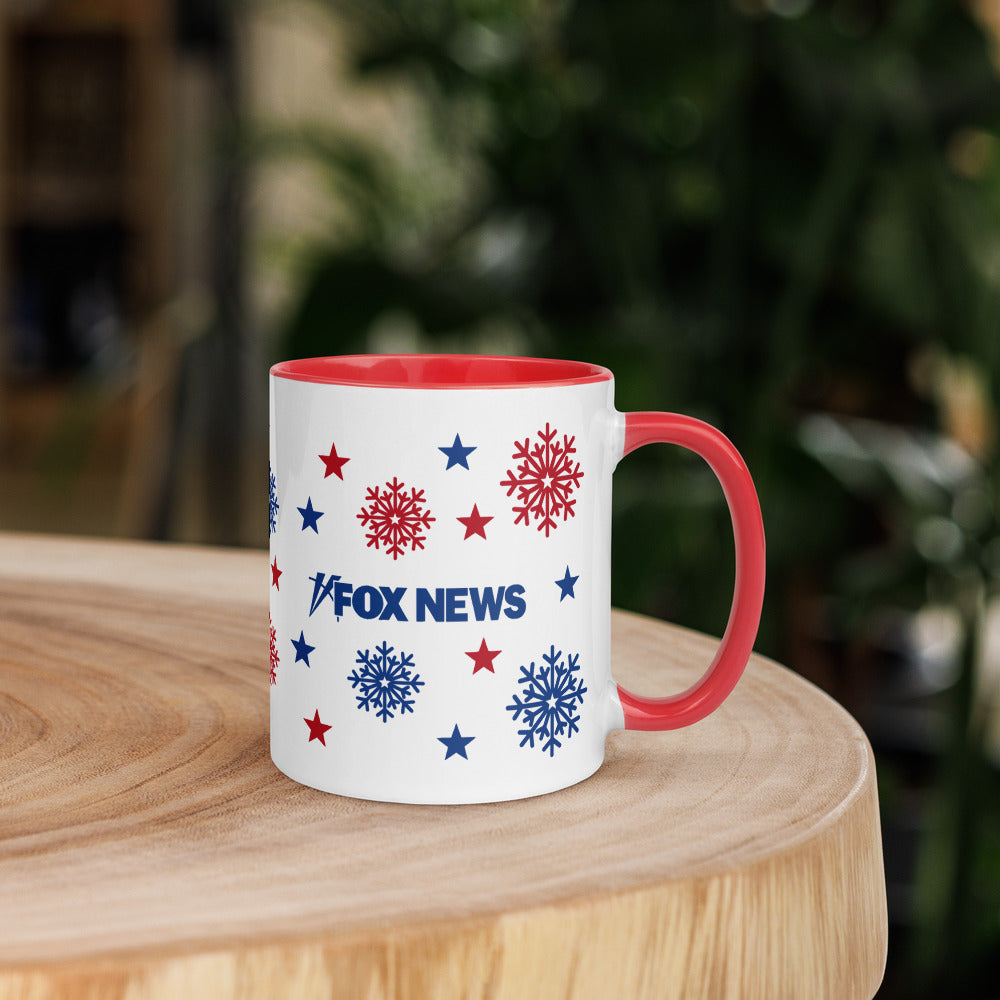 A close-up of the FOX News logo and snowflake design on a white ceramic mug with a red handle.