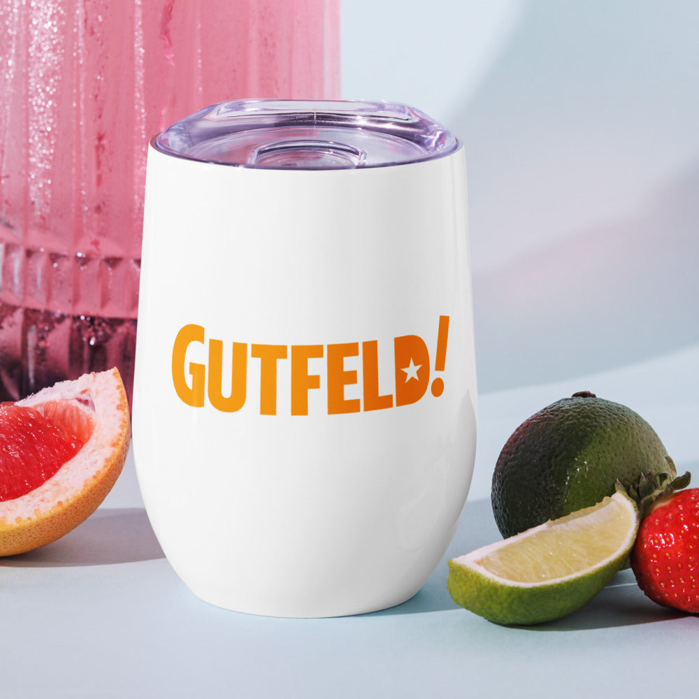 An outdoor patio table setting with the Gutfeld! hearts wine tumbler filled with a refreshing beverage in natural sunlight.