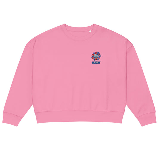 A woman standing in a bright, suburban backyard setting wearing the French Navy FOX News Proud American Mom embroidered sweatshirt.