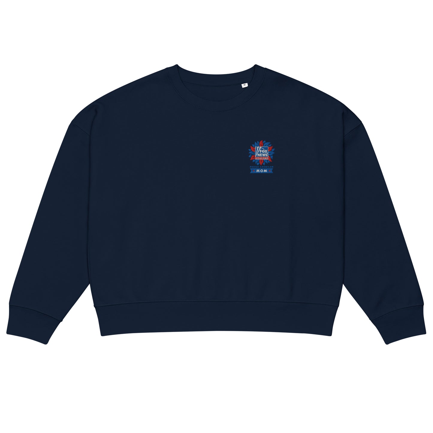A modern American living room setting featuring the FOX News Proud American Mom embroidered sweatshirt folded neatly on a neutral-toned sofa.