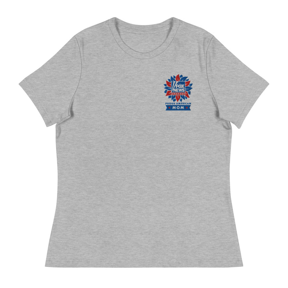A modern American living room setting featuring a proud mother wearing the FOX News Proud American Mom embroidered t-shirt with a confident smile.