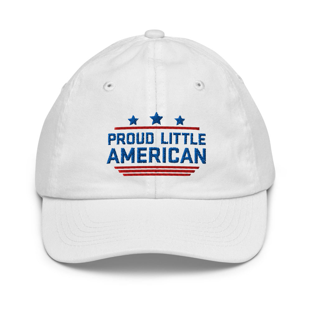A young child wearing a white FOX News Proud Little American kids hat in a sunny American backyard setting.