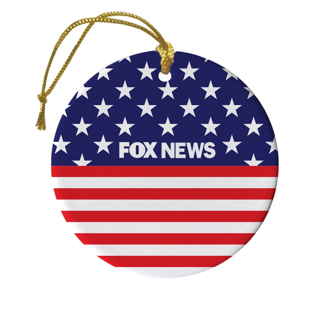 A personalized FOX News Flag Round Ornament hanging on a Christmas tree in a cozy American home setting.