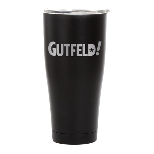 A close-up of the Gutfeld! logo on a matte black 20 oz insulated tumbler standing on a wooden coffee table.