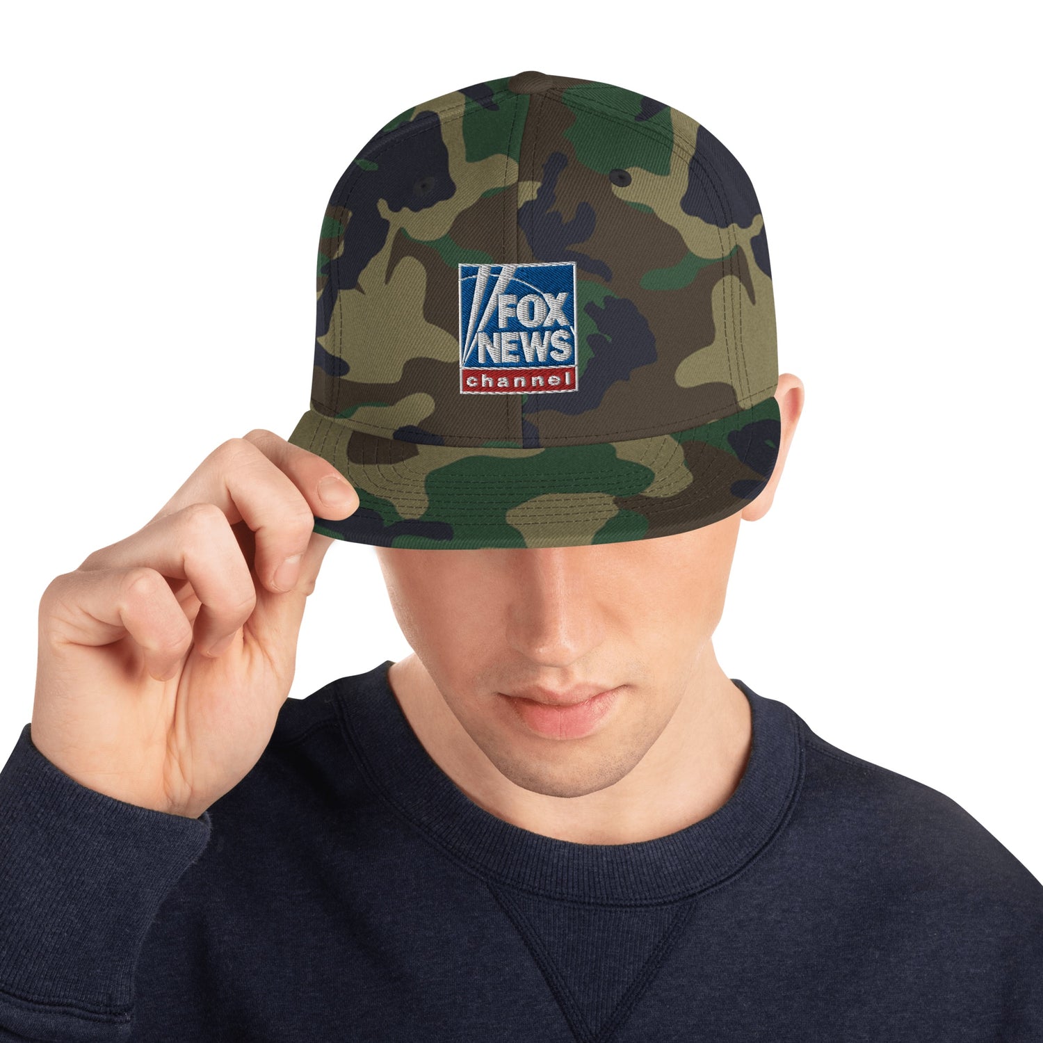 Close-up of the crisp embroidery on the FOX News logo centered on a green camo snapback cap.